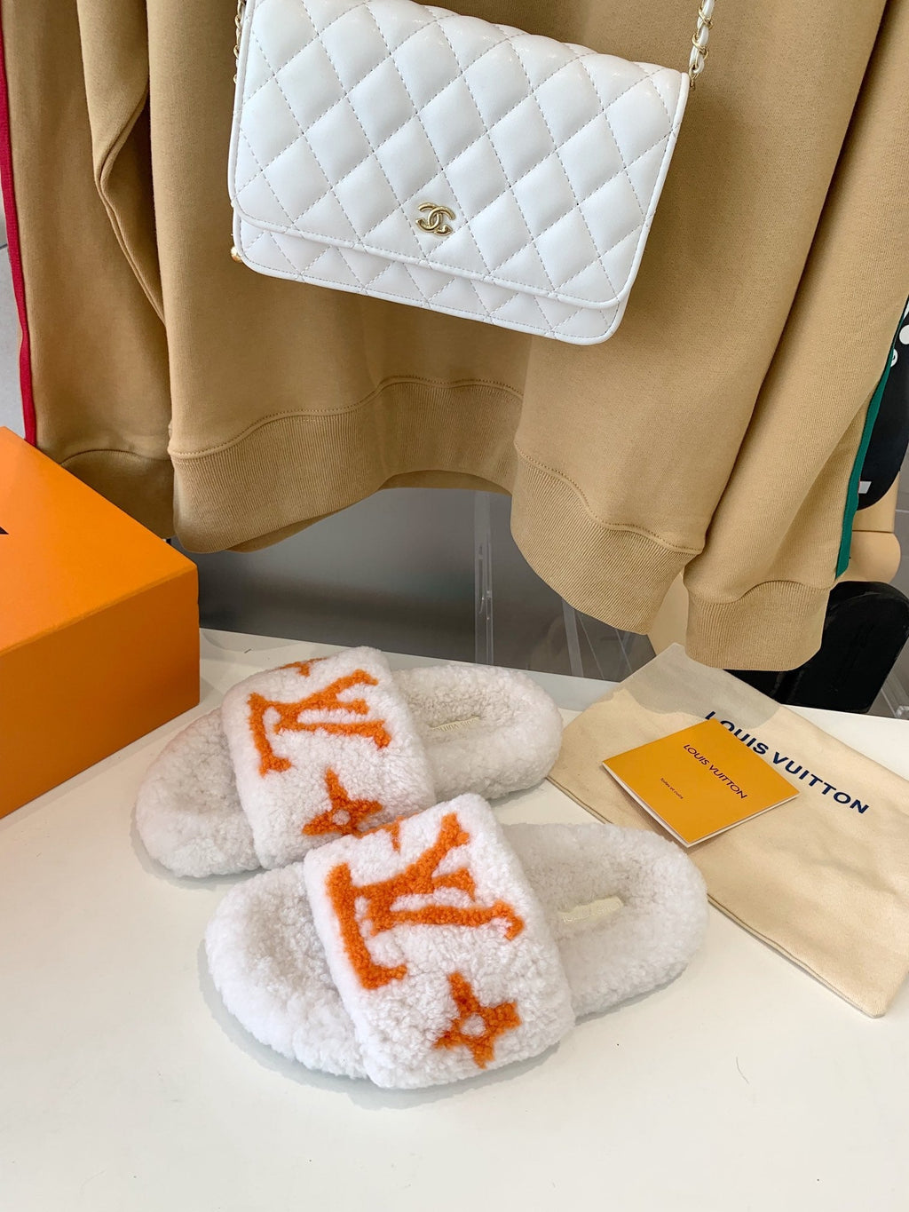 LV WOMEN'S PASEO FLAT SLIPPER IN WHITE FLEECE WITH ORANGE LOGO
