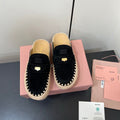MULES SLIPPERS IN BLACK SUEDE WITH GOLD COIN
