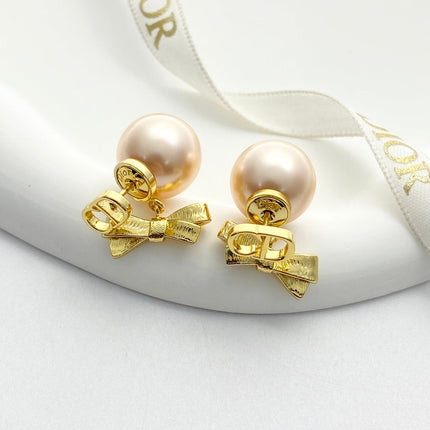 CD 26S PEARL BOW DROP EARRINGS IN GOLD TONE METAL 644484
