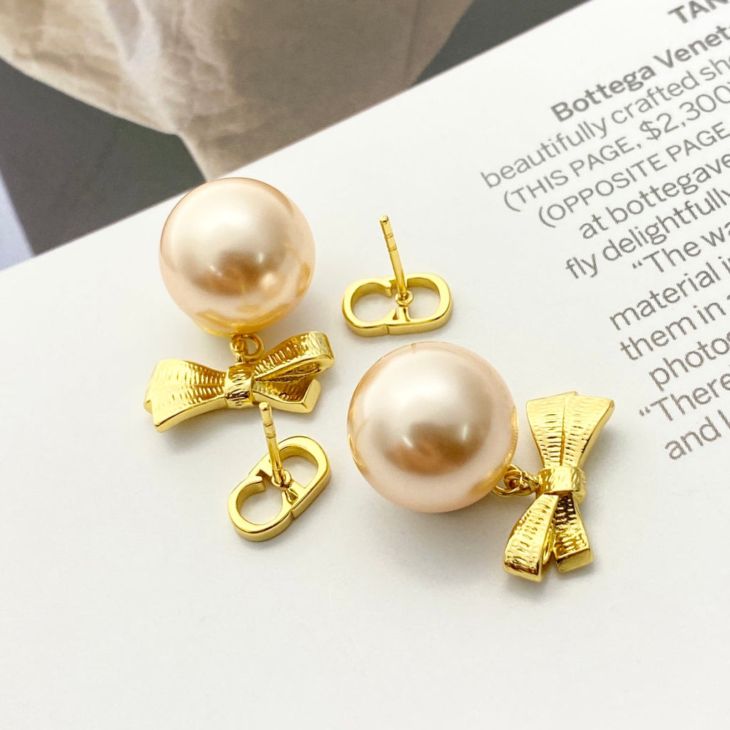 CD 26S PEARL BOW DROP EARRINGS IN GOLD TONE METAL 644484